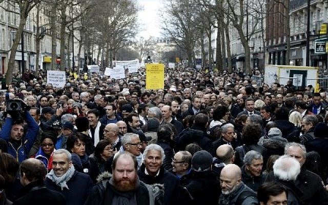 Les participants marchent derrière des banderoles tenant des pancartes lors d'une marche silencieuse à Paris en mémoire de Mireille Knoll, une Juive de 85 ans assassinée chez elle dans ce que la police a qualifié d'attaque antisémite (Crédit : François Guillot / AFP)