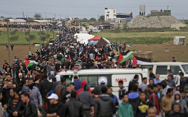 Les Palestiniens franchissent une ville de tente dressée le long de la frontière avec Israël, à l'est de Gaza City, pour commémorer la Journée de la terre (Crédit : AFP/ MAHMUD HAMS)