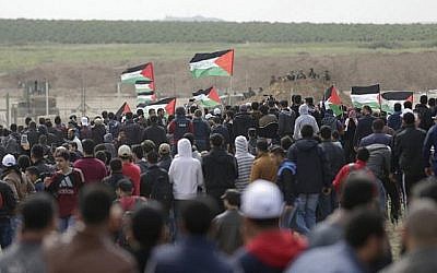 Les Palestiniens défilent devant une tente érigée le long de la frontière avec Israël à l'est de la ville de Gaza dans la bande de Gaza pour commémorer la Journée de la Terre, le 30 mars 2018 (Crédit : AFP PHOTO / MAHMUD HAMS)