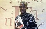 Lassana Bathily, l'employé du supermarché Hyper Cacher à Paris qui a aidé les clients à se cacher d'un tireur islamiste qui a attaqué le magasin le 9 janvier 2015, posant avec son livre "Je ne suis pas un héros", 16 décembre 2015. (AFP / Dominique Faget)