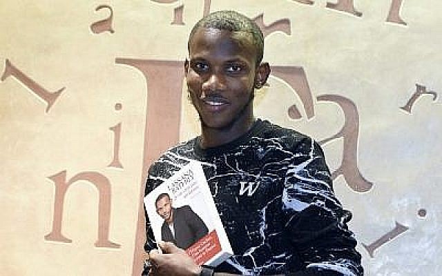 Lassana Bathily, l'employé du supermarché Hyper Cacher à Paris qui a aidé les clients à se cacher d'un tireur islamiste qui a attaqué le magasin le 9 janvier 2015, posant avec son livre "Je ne suis pas un héros", 16 décembre 2015. (AFP / Dominique Faget) Lassana Bathily, l'employé du supermarché Hyper Cacher à Paris qui a aidé les clients à se cacher d'un tireur islamiste qui a attaqué le magasin le 9 janvier 2015, posant avec son livre "Je ne suis pas un héros", 16 décembre 2015. (AFP / Dominique Faget)