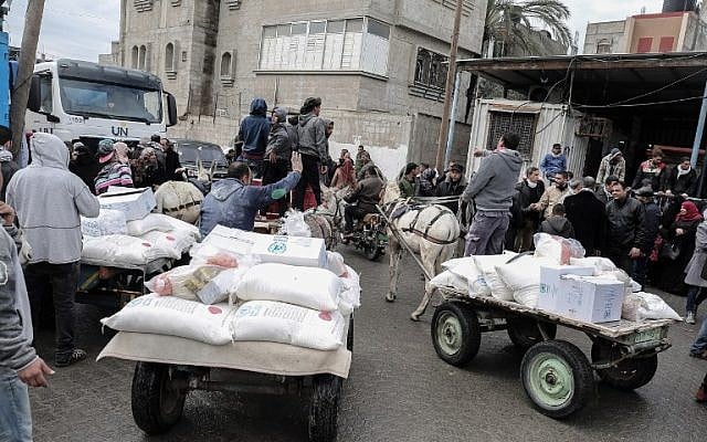 Des Palestiniens collectent des colis d'aide dans un centre de distribution alimentaire des Nations unies, à Khan Yunis, dans le sud de la bande de Gaza, le 28 janvier 2018 (Crédit : Said Khatib / AFP) Des Palestiniens collectent des colis d'aide dans un centre de distribution alimentaire des Nations unies, à Khan Yunis, dans le sud de la bande de Gaza, le 28 janvier 2018 (Crédit : Said Khatib / AFP)