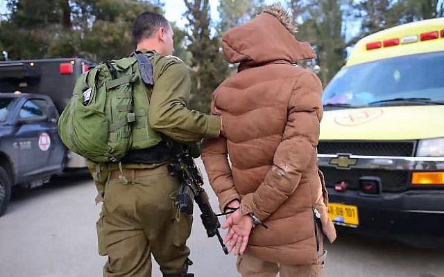 Un soldat israélien arrêtant un suspect après un raid dans la ville de Naplouse, en Cisjordanie, le 18 mars 2018. (Porte-parole de Tsahal) Un soldat israélien arrêtant un suspect après un raid dans la ville de Naplouse, en Cisjordanie, le 18 mars 2018. (Porte-parole de Tsahal)