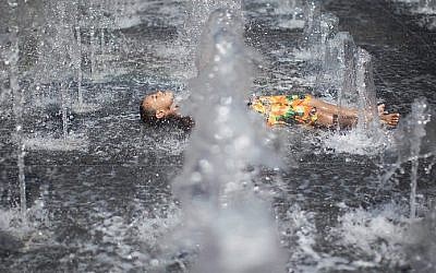 Des enfants jouent dans une fontaine d'eau lors d'une chaude journée d'été près de la tour de David dans la vieille ville de Jérusalem. (Yonatan Sindel / Flash90)