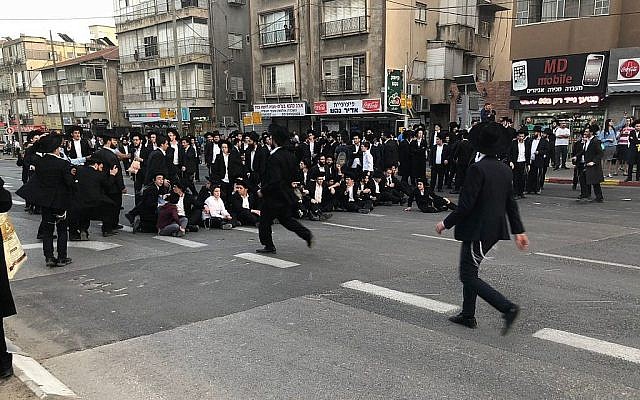 Des manifestants ultra-orthodoxes obstruent une route durant une manifestation contre le service militaire Bnei Brak le 22 mars 2018. (Crédit : police israélienne) Des manifestants ultra-orthodoxes obstruent une route durant une manifestation contre le service militaire Bnei Brak le 22 mars 2018. (Crédit : police israélienne)