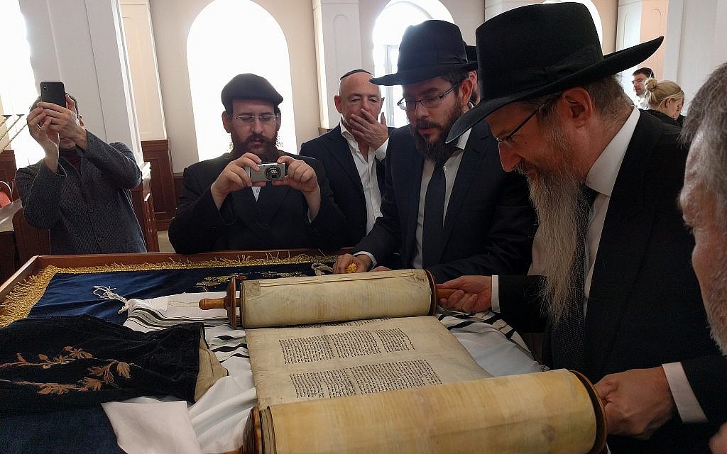De droite à gauche : le grand rabbin de Russie Berel Lazar, le rabbin Levi Kaminetsky et Baruch Ramatsky examinent le rouleau de la Torah que la famille de Ramatsky a gardé pendant les 90 dernières années, dans la synagogue principale de Tomsk, le 1er février 2018. (Yaakov Schwartz/Times of Israel)