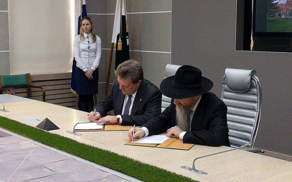 Le maire de Tomsk, Ivan Klyayn, à gauche, et le grand rabbin de Russie, Berel Lazar, signent un accord pour rendre la synagogue cantoniste à la communauté juive à l'hôtel de ville de Tomsk, le 1er février 2018. (Yaakov Schwartz/Times of Israel)