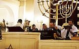 Le rabbin Michael Azoulay, (deuxième à partir de la droite), lisant la Torah avec des fidèles à la synagogue de Neuilly-sur-Seine, le 11 décembre 2017. (Crédit : Cnaan Liphshiz / JTA)
