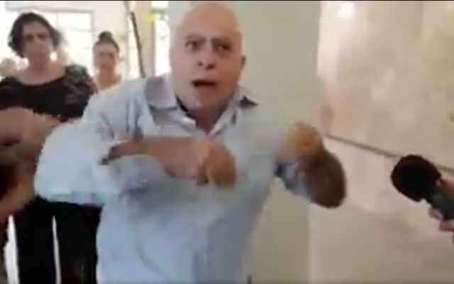 L'activiste Elie Joseph a fustigé les ventes d'armes israéliennes au Soudan du Sud, accusé de violations des droits de l'homme, après avoir été extrait d'une conférence dans la ville de Sderot, dans le sud du pays, pour avoir interrompu le discours du ministre israélien Israël Katz (Capture d’écran : Radio Israël via Twitter) L'activiste Elie Joseph a fustigé les ventes d'armes israéliennes au Soudan du Sud, accusé de violations des droits de l'homme, après avoir été extrait d'une conférence dans la ville de Sderot, dans le sud du pays, pour avoir interrompu le discours du ministre israélien Israël Katz (Capture d’écran : Radio Israël via Twitter)