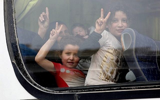 Des enfants syriens évacués de la région de la Ghouta orientale à la fenêtre d'un bus alors qu'ils arrivent à Qalaat al-Madiq, à 45 kilomètres au nord-ouest de la ville de Hama, le 28 mars 2018, suite à un accord d'évacuation entre la faction rebelle islamiste Faylaq al-Rahman, qui contrôle une partie de la Ghouta, et la Russie, un allié du président syrien (AFP PHOTO / OMAR HAJ KADOUR) Des enfants syriens évacués de la région de la Ghouta orientale à la fenêtre d'un bus alors qu'ils arrivent à Qalaat al-Madiq, à 45 kilomètres au nord-ouest de la ville de Hama, le 28 mars 2018, suite à un accord d'évacuation entre la faction rebelle islamiste Faylaq al-Rahman, qui contrôle une partie de la Ghouta, et la Russie, un allié du président syrien (AFP PHOTO / OMAR HAJ KADOUR)