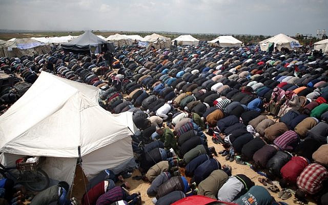 Les fidèles musulmans font la prière du vendredi, à midi, près d'une ville en tentes aux abords de la frontière avec Israël, à l'est de Jabalia, le 30 mars 2018 (Crédit : AFP/Mohammed Abed) Les fidèles musulmans font la prière du vendredi, à midi, près d'une ville en tentes aux abords de la frontière avec Israël, à l'est de Jabalia, le 30 mars 2018 (Crédit : AFP/Mohammed Abed)