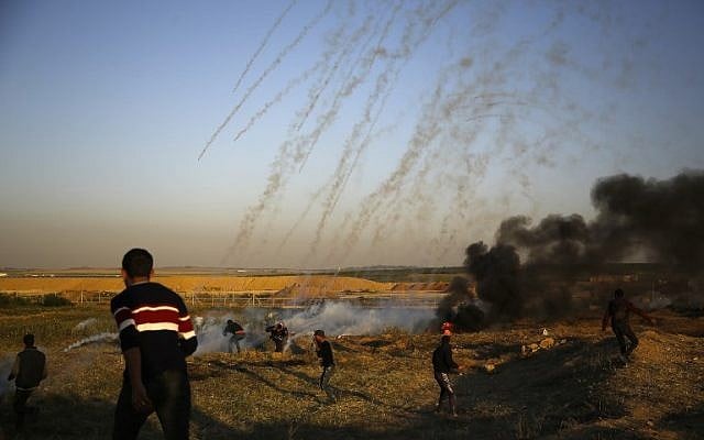 Des manifestants palestiniens courent pour échapper au gaz lacrymogène lancé par les forces israéliennes durant des affrontements qui ont suivi une manifestation le long de la frontière avec Israël, à l'est de Gaza City, le 1er avril 2018 (Crédit : Mohammed Abed/AFP) Des manifestants palestiniens courent pour échapper au gaz lacrymogène lancé par les forces israéliennes durant des affrontements qui ont suivi une manifestation le long de la frontière avec Israël, à l'est de Gaza City, le 1er avril 2018 (Crédit : Mohammed Abed/AFP)