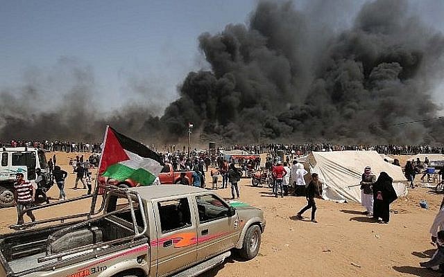 Des manifestants palestiniens brûlent des pneus pendant des affrontements avec les forces de sécurité israéliennes sur la frontière entre Gaza et Israël, le 6 avril 2018 (Crédit : AFP PHOTO / SAID KHATIB) Des manifestants palestiniens brûlent des pneus pendant des affrontements avec les forces de sécurité israéliennes sur la frontière entre Gaza et Israël, le 6 avril 2018 (Crédit : AFP PHOTO / SAID KHATIB)