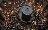 Les fidèles chrétiens orthodoxes tiennent des bougies allumées au "feu sacré" lors d'un rassemblement à l'église du Saint-Sépulcre de la Vieille Ville de Jérusalem lors de la Pâque orthodoxe, le 7 avril 2018. (Crédit : AFP PHOTO / GALI TIBBON)