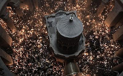 Les fidèles chrétiens orthodoxes tiennent des bougies allumées au "feu sacré" lors d'un rassemblement à l'église du Saint-Sépulcre de la Vieille Ville de Jérusalem lors de la Pâque orthodoxe, le 7 avril 2018. (Crédit : AFP PHOTO / GALI TIBBON)