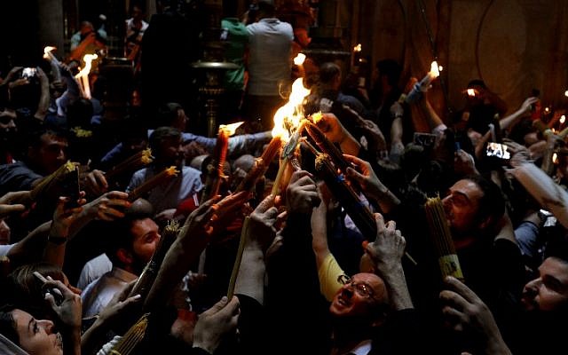 Les fidèles chrétiens orthodoxes tiennent des bougies allumées au "feu sacré" lors d'un rassemblement à l'église du Saint-Sépulcre de la Vieille Ville de Jérusalem lors de la Pâque orthodoxe, le 7 avril 2018
(Crédit : AFP PHOTO / GALI TIBBON) Les fidèles chrétiens orthodoxes tiennent des bougies allumées au "feu sacré" lors d'un rassemblement à l'église du Saint-Sépulcre de la Vieille Ville de Jérusalem lors de la Pâque orthodoxe, le 7 avril 2018
(Crédit : AFP PHOTO / GALI TIBBON)