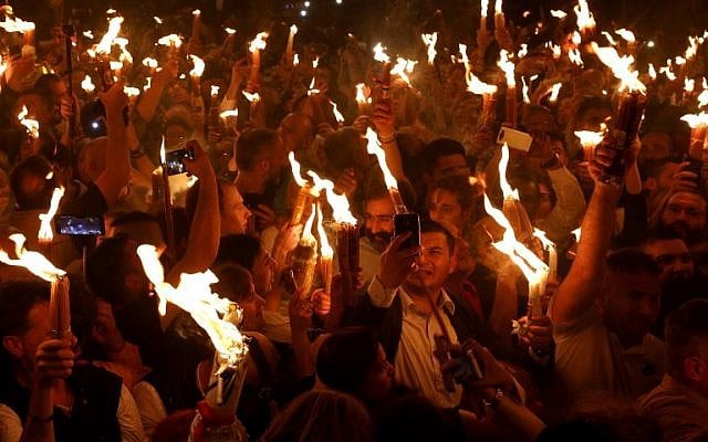 Les fidèles chrétiens orthodoxes tiennent des bougies allumées au "feu sacré" lors d'un rassemblement à l'église du Saint-Sépulcre de la Vieille Ville de Jérusalem lors de la Pâque orthodoxe, le 7 avril 2018
(Crédit : AFP PHOTO / GALI TIBBON) Les fidèles chrétiens orthodoxes tiennent des bougies allumées au "feu sacré" lors d'un rassemblement à l'église du Saint-Sépulcre de la Vieille Ville de Jérusalem lors de la Pâque orthodoxe, le 7 avril 2018
(Crédit : AFP PHOTO / GALI TIBBON)