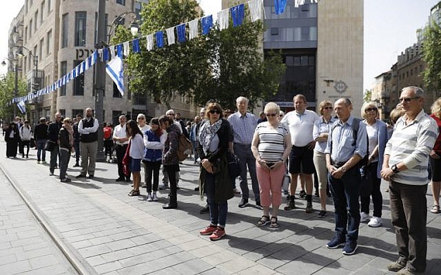 Les gens s'arrêtent et restent silencieux sur une rue du centre-ville de Jérusalem le 12 avril 2018, alors que les sirènes retentissent à travers Israël pendant deux minutes pour marquer Yom HaShoah (Crédit : PHOTO AFP / Menahem KAHANA)