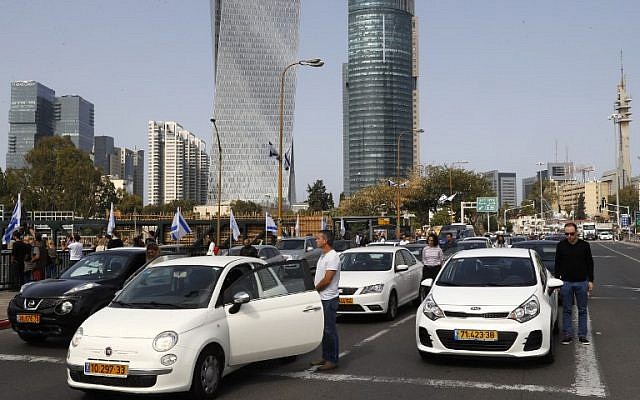 Les gens s'arrêtent et restent silencieux sur une rue du centre-ville de Tel Aviv le 12 avril 2018, alors que les sirènes retentissent à travers Israël pendant deux minutes pour marquer Yom HaShoah (Crédit : PHOTO AFP / Jack Guez)