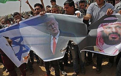 Les Palestiniens s'apprêtent à incendier un drapeau israélien et des portraits du président américain Donald Trump et du prince héritier saoudien Mohammed ben Salmane lors d'une manifestation contre la barrière frontalière avec Israël, à l'est de Khan Younès, au sud de Gaza, le 13 avril 2018. (Crédit : AFP PHOTO / Thomas COEX)