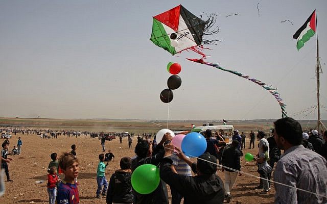 Des Palestiniens font voler un cerf-volant alors qu'ils se rassemblent à la frontière avec Israël, à l'est de Jabalia, dans le centre de la ville de Gaza, lors d'une manifestation le 13 avril 2018 (Crédit : AFP / Mohammed Abed) Des Palestiniens font voler un cerf-volant alors qu'ils se rassemblent à la frontière avec Israël, à l'est de Jabalia, dans le centre de la ville de Gaza, lors d'une manifestation le 13 avril 2018 (Crédit : AFP / Mohammed Abed)