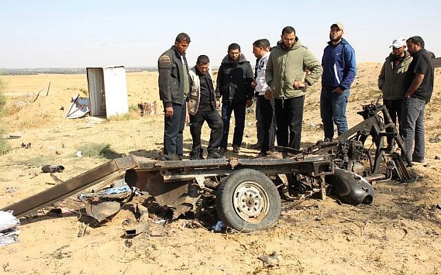 Des Palestiniens observent les débris d'un véhicule en tuk tuk sur le site d'une explosion à l'est de Rafah, dans le sud de la bande de Gaza, le 14 avril 2018. Quatre terroristes du Jihad islamique sont morts dans l'explosion, à quelques mètres de la frontière avec Israël (Crédit : AFP / SAID KHATIB) Des Palestiniens observent les débris d'un véhicule en tuk tuk sur le site d'une explosion à l'est de Rafah, dans le sud de la bande de Gaza, le 14 avril 2018. Quatre terroristes du Jihad islamique sont morts dans l'explosion, à quelques mètres de la frontière avec Israël (Crédit : AFP / SAID KHATIB)
