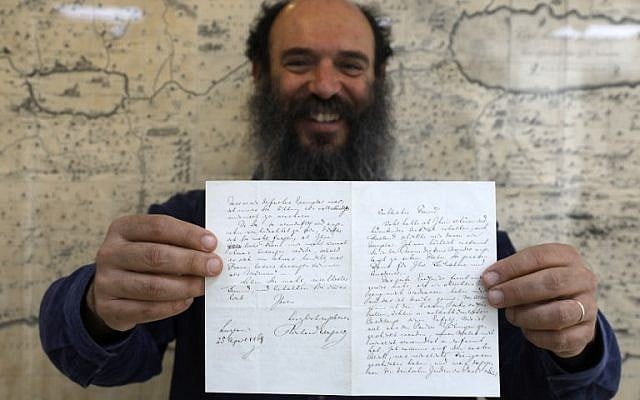 Meron Eren, co-fondateur et propriétaire de la maison d'enchères Kedem, tient une lettre du compositeur antisémite allemand Richard Wagner à Jérusalem le 16 avril 2018. (Crédit : Menahem Kahana / AFP)