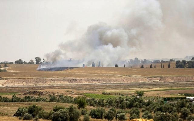 La fumée et les flammes montent des champs près du kibboutz Beeri du côté israélien de la bande de Gaza à l'est de la ville de Gaza, après que les Palestiniens ont envoyé un cerf-volant avec un cocktail Molotov au-dessus de la frontière et qui est tombé en territoire israélien le 17 avril 2018 (Crédit : AFP / Mahmud Hams) La fumée et les flammes montent des champs près du kibboutz Beeri du côté israélien de la bande de Gaza à l'est de la ville de Gaza, après que les Palestiniens ont envoyé un cerf-volant avec un cocktail Molotov au-dessus de la frontière et qui est tombé en territoire israélien le 17 avril 2018 (Crédit : AFP / Mahmud Hams)