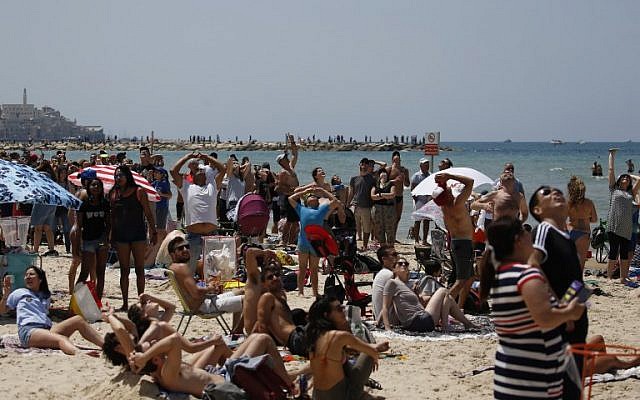 Des Israéliens et des touristes regardent un spectacle aérien pendant les festivités du 70ème Jour de l'Indépendance, le 19 avril 2018 dans la ville côtière méditerranéenne de Tel Aviv (Crédit : AFP PHOTO / AHMAD GHARABLI)