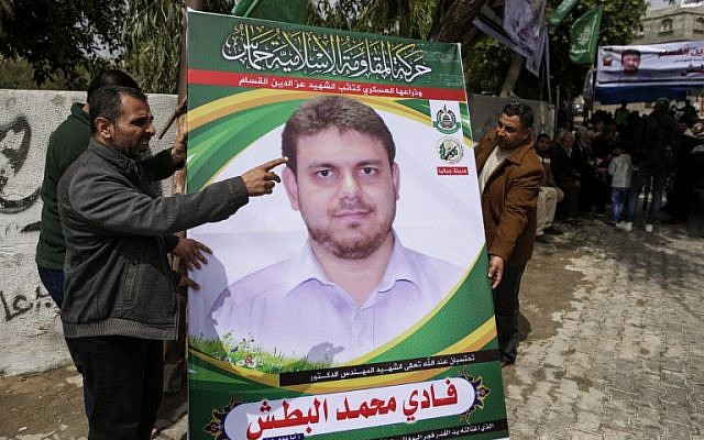 Deux hommes placardant la photo d'un membre du Hamas, Fadi Mohammad al-Batsh âgé de 35 ans, devant la maison de sa famille, à Jabaliya, au nord de la bande de Gaza, le 21 avril 2018. (Crédit : AFP/Mahmud Hams) Deux hommes placardant la photo d'un membre du Hamas, Fadi Mohammad al-Batsh âgé de 35 ans, devant la maison de sa famille, à Jabaliya, au nord de la bande de Gaza, le 21 avril 2018. (Crédit : AFP/Mahmud Hams)