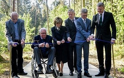 De gauche à droite : Henrik Mordechai Gideon, survivant de l'Holocauste et ancien prisonnier du camp de concentration de Muehldorf du Muehldorfer Hart, Hans-Jochen Vogel, ancien leader du parti social-démocrate SPD et vice-président du centre de documentation de Munich  pour l'Histoire du national-socialisme,  Charlotte Knobloch, présidente de la communauté juive de Munich, Karl Freller, vice-président du groupe parlementaire du parti conservateur  CSU au parlement de Bavière,  le ministre de la Culture de Bavière Bernd Sibler et le ministre de l'environnement et de la protection des consommateurs de Bavière Marcel Huber coupent le ruban lors de l'inauguration de la partie "Waldlager" du site de commémoration du camp Muehldorfer Hart  à proximité de Waldkraiburg, dans le sud de l'Allemagne, le 27 avril 2018 (Crédit : AFP PHOTO / dpa / Matthias Balk)