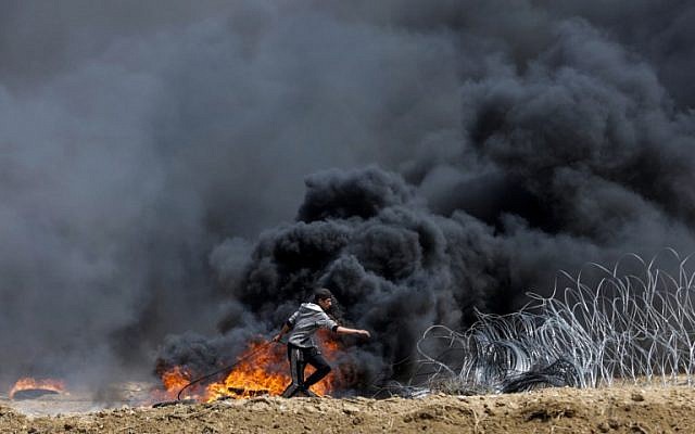 Un Palestinien tente de faire tomber une partie de la barrière frontalière entre Israël et Gaza à l'est de la ville de Gaza, dans le centre de la bande de Gaza, lors du cinquième vendredi consécutif d'émeutes de masse le long de la frontière entre Gaza et Israël, le 27 avril 2018. (AFP Photo/Mahmud Hams) Un Palestinien tente de faire tomber une partie de la barrière frontalière entre Israël et Gaza à l'est de la ville de Gaza, dans le centre de la bande de Gaza, lors du cinquième vendredi consécutif d'émeutes de masse le long de la frontière entre Gaza et Israël, le 27 avril 2018. (AFP Photo/Mahmud Hams)