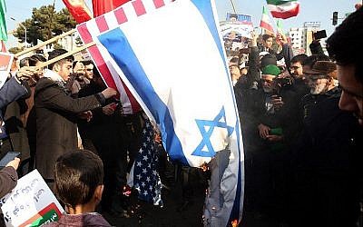 Des partisans iraniens favorables au gouvernement brûlent les drapeaux israéliens et américains lors d'un rassemblement à Mashhad en soutien au régime après que les autorités ont déclaré la fin des récentes manifestations, le 4 janvier 2018 (Crédit : AFP Photo / Tasnim News / Nima Najafzadeh)