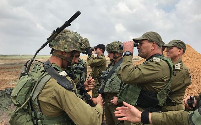 Le chef du Commandement du sud de l'armée israélienne, le général de division  Eyal Zamir,  regarde à travers une paire de lunette pour mieux voir la situation dans la bande de Gaza alors que le chef des opérations de l'armée, le général de division Nitzan Alon, se tient derrière durant une manifestation massive le long de la frontière, le 30 mars 2018 (Crédit : Armée israélienne)