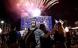 Des Israéliens devant le feux d'artifice lors d'une soirée marquant le 70e anniversaire de l'indépendance d'Israël à Tel Aviv, le 18 avril 2018 (Miriam Alster / Flash90)