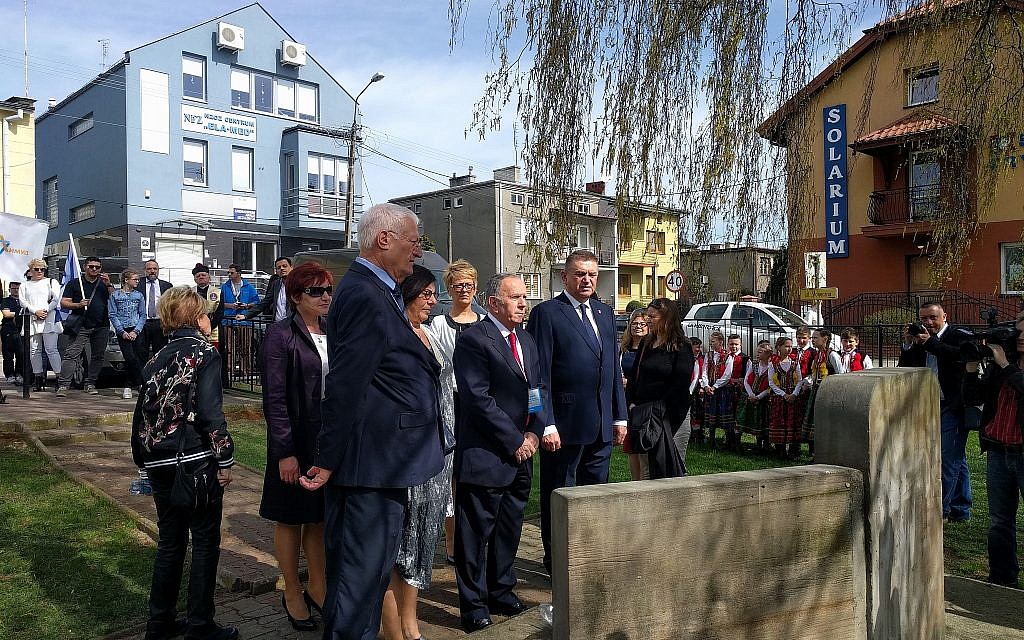 De gauche à droite : Chaim Chessler, co-fondateur du Limmud FSU, Aharon Tamir, vice-président de la Marche des vivants, et le maire Andrzej Pietrasik déposent des couronnes devant l’ancienne maison de l'ancien premier ministre israélien David Ben Gourion à Plonsk, en Pologne, le 15 avril 2018 (Yaakov Schwartz / Times of Israël)