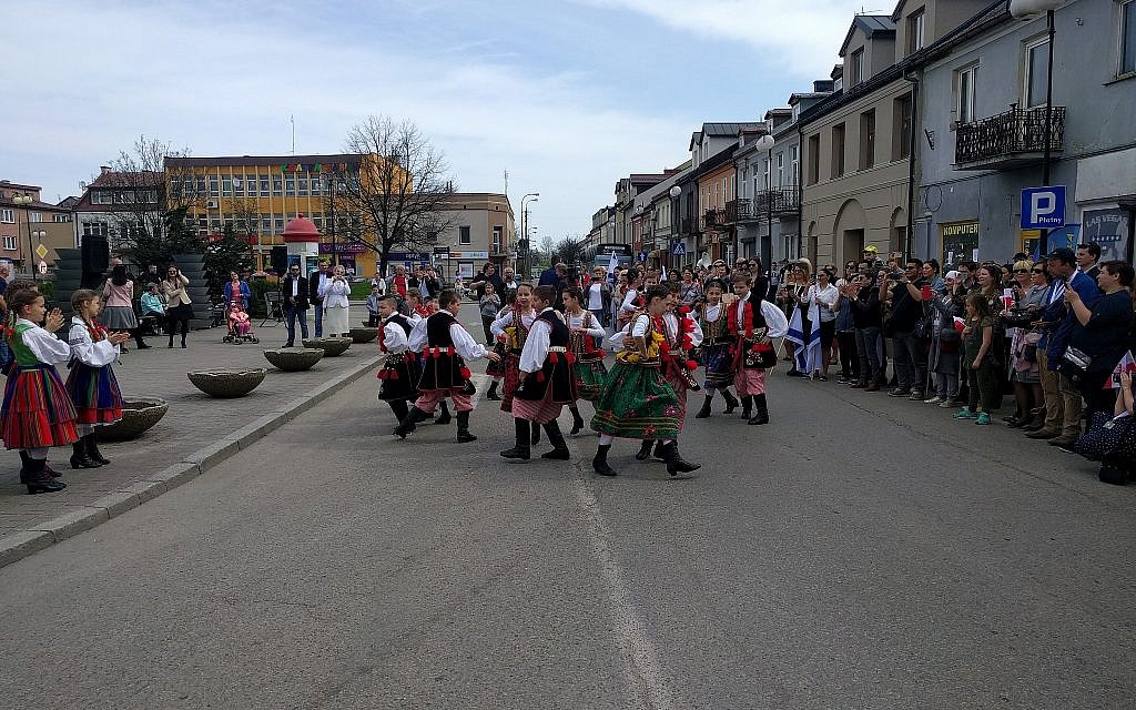 Des enfants polonais habillés avec des costumes colorés lors d’une danse traditionnelle lors d'un événement marquant les 70 ans d'indépendance d'Israël, dans la ville de naissance de David Ben Gourion à Plonsk, en Pologne, le 15 avril 2018 (Yaakov Schwartz / Times of Israël)