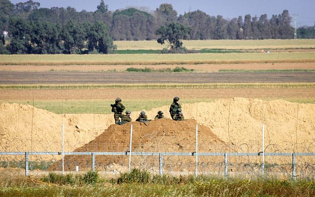 Des soldats israéliens regardent des manifestants palestiniens suite à une manifestation aux abords de la frontière avec Israël, à l'est de Khan Younis, dans le sud de la bande de Gaza, le 31 mars 2018 (Crédit : Abed Rahim Khatib/ Flash90) Des soldats israéliens regardent des manifestants palestiniens suite à une manifestation aux abords de la frontière avec Israël, à l'est de Khan Younis, dans le sud de la bande de Gaza, le 31 mars 2018 (Crédit : Abed Rahim Khatib/ Flash90)