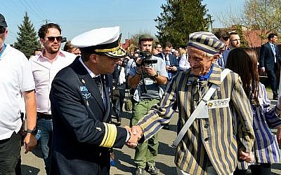 Un haut responsable militaire (à gauche) serre la main du survivant de la Shoah Edward Mossberg lors de la Marche des vivants en Pologne le 12 avril 2018 (crédit : Yossi Zeliger / Flash90)