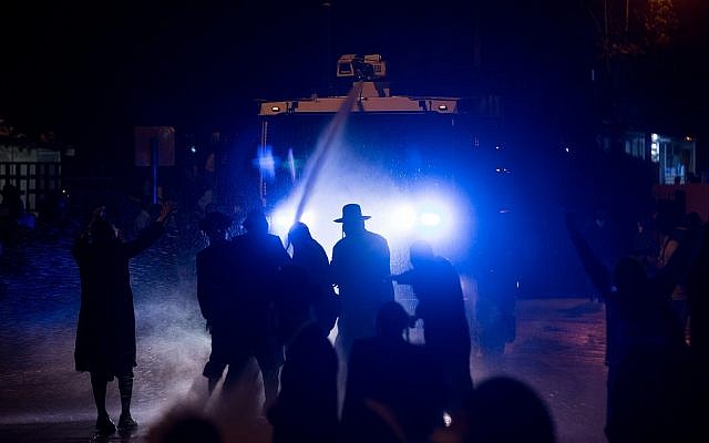 La police israélienne utilise un canon à eau contre les manifestants juifs ultra-orthodoxes lors d'une manifestation devant le bureau de recrutement de l'armée à Jérusalem, à la suite de l'arrestation d'une femme juive ultra-orthodoxe. 15 avril 2018. (Yonatan Sindel/Flash90)