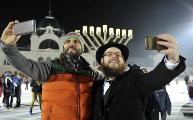 Le rabbin Slomo Koves, (à droite), et un participant à l'événement Hanukkah on Ice organisé par le mouvement Habad de Hongrie en 2015 à la patinoire du parc municipal de Budapest, le 6 décembre 2015. (Avec l'aimable autorisation de EMIH/via JTA) Le rabbin Slomo Koves, (à droite), et un participant à l'événement Hanukkah on Ice organisé par le mouvement Habad de Hongrie en 2015 à la patinoire du parc municipal de Budapest, le 6 décembre 2015. (Avec l'aimable autorisation de EMIH/via JTA)