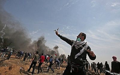 Un manifestant palestinien utilise un lance-pierre pour affronter les forces de sécurité israéliennes près de Khan Younis, dans le sud de la bande de Gaza, le vendredi 27 avril 2018 (Photo AFP / Said Khatib)