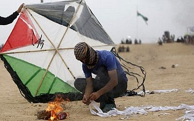 Un Palestinien prépare un dispositif incendiaire attaché à un cerf-volant avant de tenter de le lancer à la clôture frontalière avec Israël, au sud de Jabalia, dans la bande de Gaza, le 4 mai 2018 (Crédit : Mohammed Abed/AFP)