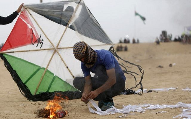 Un Palestinien prépare un dispositif incendiaire attaché à un cerf-volant avant de tenter de le lancer à la clôture frontalière avec Israël, au sud de Jabalia, dans la bande de Gaza, le 4 mai 2018 (Crédit : Mohammed Abed/AFP) Un Palestinien prépare un dispositif incendiaire attaché à un cerf-volant avant de tenter de le lancer à la clôture frontalière avec Israël, au sud de Jabalia, dans la bande de Gaza, le 4 mai 2018 (Crédit : Mohammed Abed/AFP)