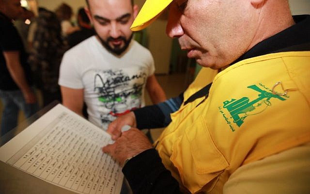 Un délégué du Hezbollah vérifie les listes des électeurs dans un bureau de vote d'un quartier du sud de Beyrouth, au Liban, lors des premières élections parlementaires en neuf ans, le 6 mai 2018 (Crédit : / AFP PHOTO / ANWAR AMRO) Un délégué du Hezbollah vérifie les listes des électeurs dans un bureau de vote d'un quartier du sud de Beyrouth, au Liban, lors des premières élections parlementaires en neuf ans, le 6 mai 2018 (Crédit : / AFP PHOTO / ANWAR AMRO)