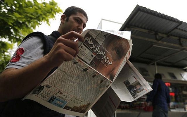 Un Iranien lit son journal au lendemain du retrait des Etats-Unis de l'accord sur le nucléaire décidé par le président Donald Trump (portrait), le 9 mai 2018 (Crédit : / AFP PHOTO / ATTA KENARE)