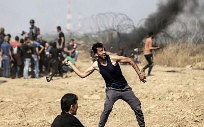 Un manifestant palestinien jette des pierres lors d'affrontements avec les forces israéliennes le long de la frontière avec la bande de Gaza, à l'est de la ville de Gaza, le 11 mai 2018. (AFP PHOTO / MAHMUD HAMS)