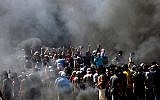 Des Palestiniens crient des slogans lors d'affrontements avec les forces de sécurité israéliennes près de la frontière entre la bande de Gaza et Israël, à l'est de la ville de Gaza, le 14 mai 2018. (MAHMUD HAMS/AFP)