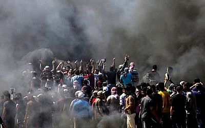 Des Palestiniens scandent des slogans lors d'affrontements avec les forces de sécurité israéliennes près de la frontière entre la bande de Gaza et Israël à l'est de la ville de Gaza le 14 mai 2018. (MAHMUD HAMS/AFP)