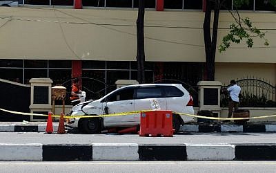 Des policiers indonésiens examinent la voiture utilisée par les terroristes devant le siège de la police à Pekanbaru, à Riau , après l'attentat commis le 16 mai 2018 (Crédit : AFP PHOTO / DEDY SUTISNA
